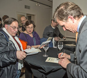 Chief Financial Officer Joe Corbett signs programs at the Martín Ramírez stamps dedication.