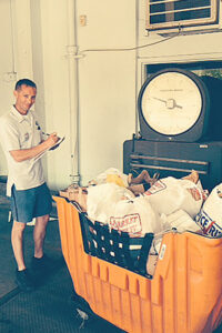 Brockton, MA, Letter Carrier Sean O'Malley weighs a hamper of food donations.