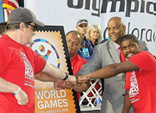 Colorado/Wyoming District Manager Selwyn Epperson helps dedicate the Special Olympics World Games stamp.