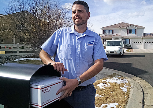 Broomfield, CO, Letter Carrier J.D. Kohl stands near one of the test mailboxes