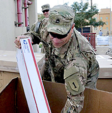 Sgt. 1st Class Roy Frazier retrieves a package at a postal unit in Iraq.