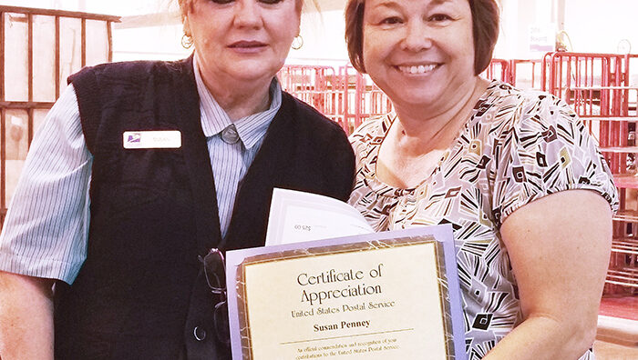 Employee receives certificate from Postmaster