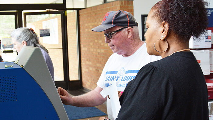 Des Peres, MO, Customer Services Supervisor Christy Zomphier helps customer Robert Hughes use a self-service kiosk.