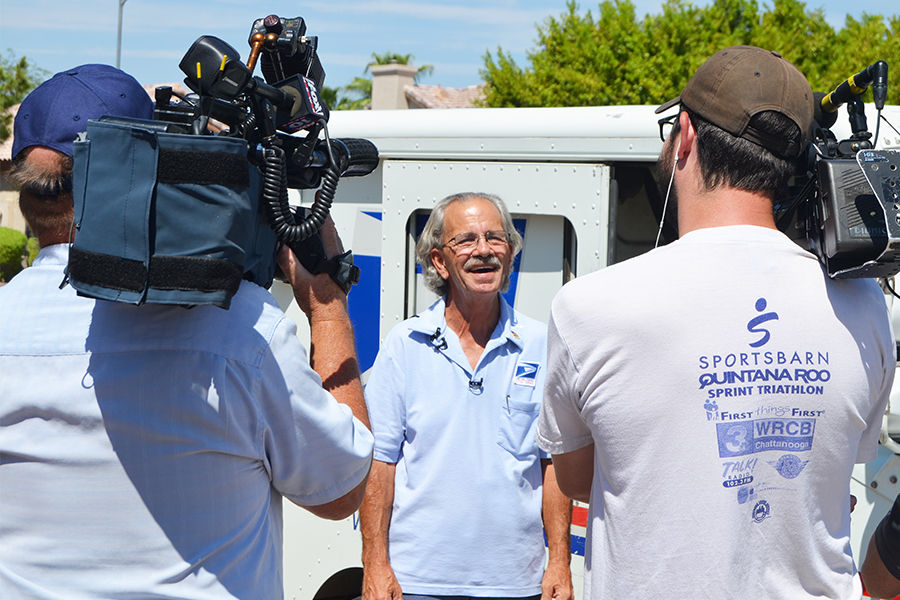 Glendale, AZ, Letter Carrier Michael Raymer is interviewed by local TV news crews.