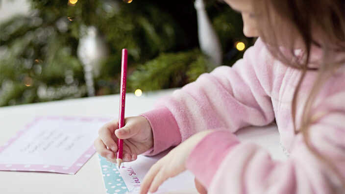 A girl writing a letter to Santa Claus.