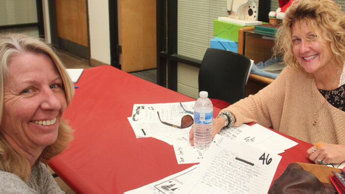 Customers Judy Brunelle and Paula Chambers review Operation Santa letters in Santa Ana District.