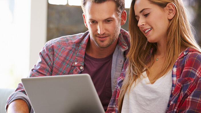 Two people looking a t a laptop.