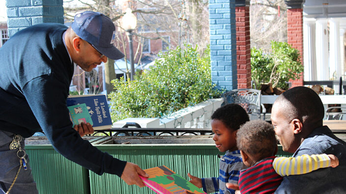 Letter Carrier Paul Hall delivers books to a child in Washington, DC, recently.