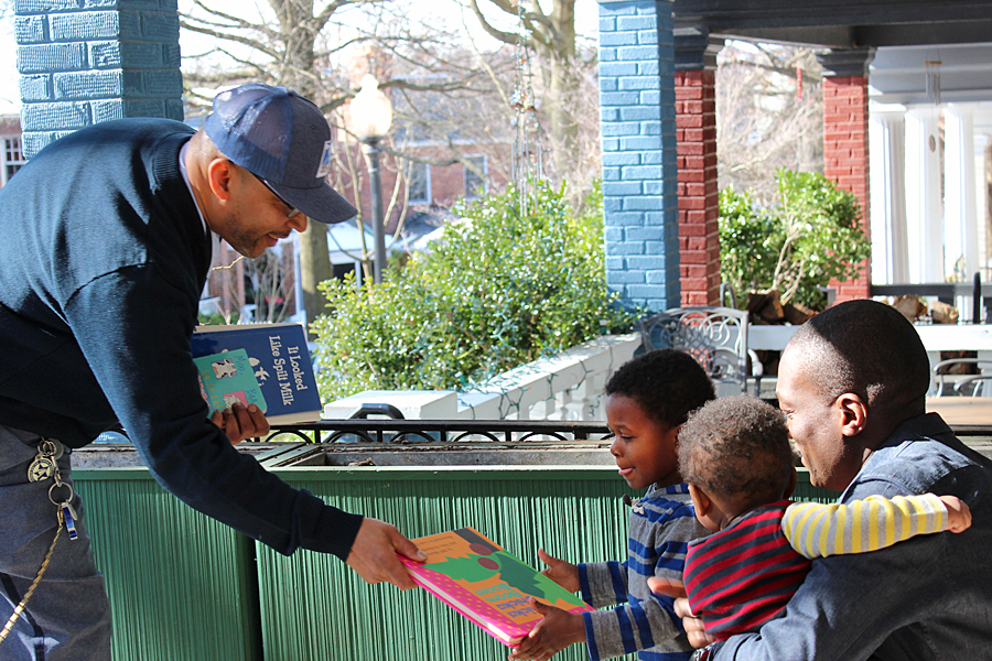 Letter Carrier Paul Hall delivers books to a child in Washington, DC, recently.