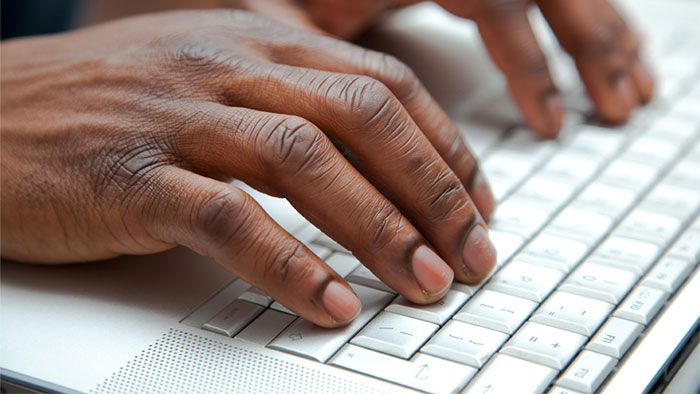 Someone typing on a computer keyboard.