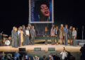 Participants gather on stage following the stamp unveiling.