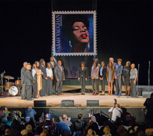 Participants gather on stage following the stamp unveiling.