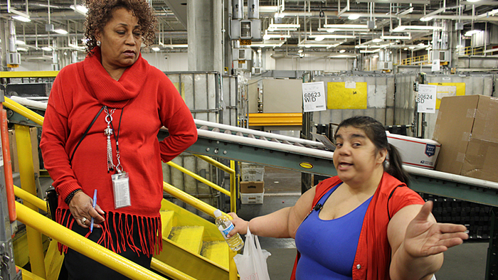 Greater Indiana District Distribution Operations Manager Cherie Harwell, a member of the team helping Chicago District strengthen service, speaks to Parcel Post Distribution Clerk Linda Starr at the Cardiss Collins Processing and Distribution Center.