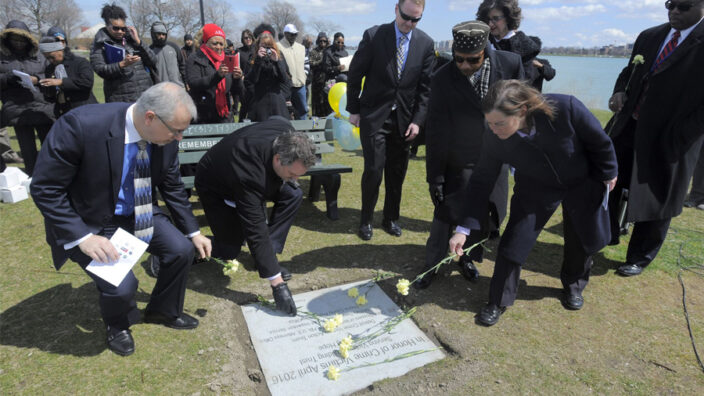 Detroit Postal Inspector in Charge E.C. Woodson, far right, helps lay flowers in a Detroit park to honor crime victims April 10. Also pictured are representatives from other law enforcement agencies, including the Bureau of Alcohol, Firearms and Explosives, the U.S. Drug Enforcement Administration and the FBI. Image: DetroitNews.com.