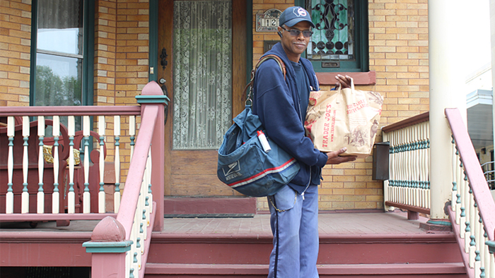 Oak Park, IL, Letter Carrier Keith Scott collects donations during last year’s Stamp Out Hunger food drive.