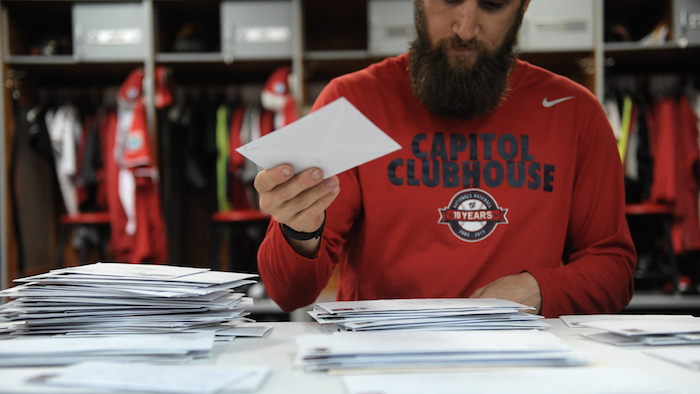 Team assistant Andrew Melnick sorts fan mail in the Washington Nationals clubhouse.