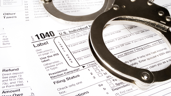 A pair of handcuffs on top of a 1040 tax form.