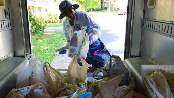 Letter carrier loading food donations