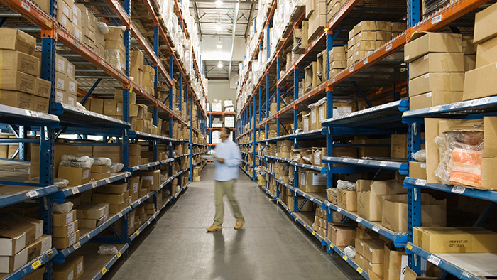 Man standing in warehouse aisle.