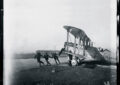 A plane’s engine is cranked in the early 1920s.