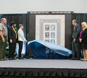 Participants unveil the Classics Forever stamps at the show.