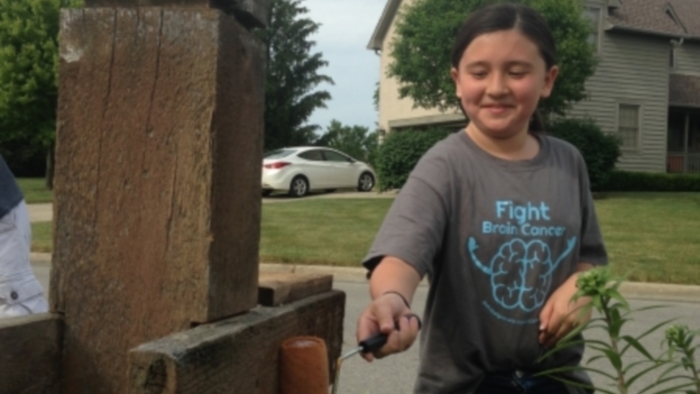 Campbell Goh-Johnson, 11, paints a mailbox to raise money for her ill father. Image: The Columbus Dispatch