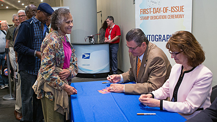 Stamp collectors line up to have their programs autographed by Chief Marketing and Sales Officer Jim Cochrane, Northeast Area Marketing Manager Laurie Timmons and others May 28.