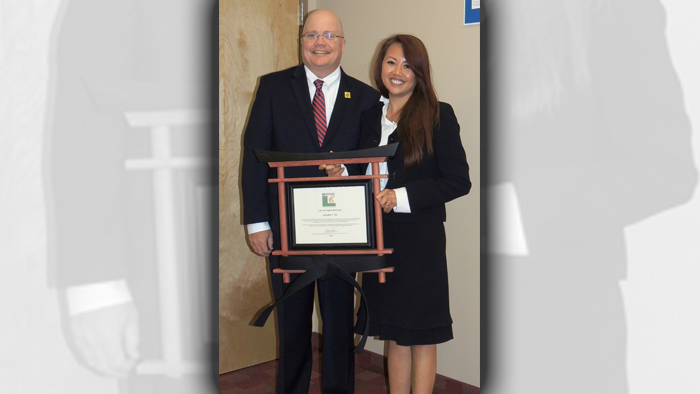 Chief Operating Officer David Williams presents Philadelphia Postmaster Jennifer Vo with her black-belt certification.