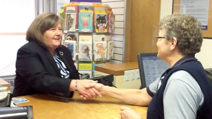 PMG Megan J. Brennan greets Retail Associate Deb Striefel during a visit to the Mandan, ND, Post Office last week.