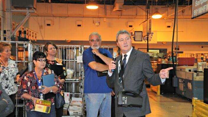 Maintenance Manager William Bartley leads business mailers on a tour of the Louisville, KY, Processing and Distribution Center during last year’s National PCC Week.