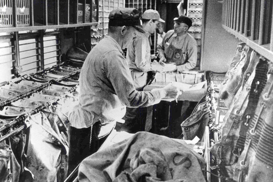 Clerks sort mail in the cramped interior of a Railway Post Office, which typically ranged from 15-60 feet long to about 9 feet wide.