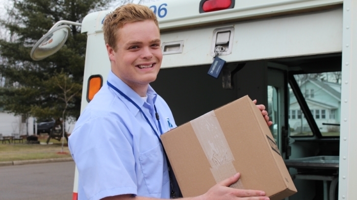 Sandusky, MI, City Carrier Assistant Max Martin delivers a package, one of several USPS services praised this week by the Houston Chronicle.