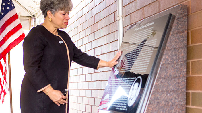Joan Jackson, Joseph Curseen Jr.’s sister, touches the plaque that honors him and Thomas Morris Jr. during the Oct. 21 dedication ceremony.