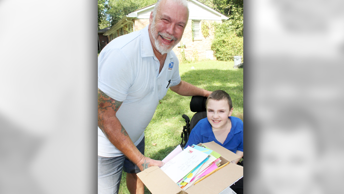 Marietta, GA, Letter Carrier Scott Wilson with Chase Howard and some of the 7,000 cards received from around the world.