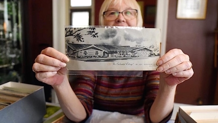 Beverly Tetterton, who has been collecting postcards since she was a child, holds a card that shows a picture of her sister’s first house. Image: StarNews