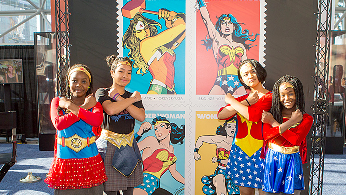 Members of Girls Inc., a nonprofit organization whose mission is giving confidence to girls, pose near a display at the Oct. 7 Wonder Woman stamp dedication.