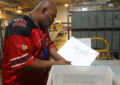 Monty Trabue, a mail handler at the Louisville, KY, Processing and Distribution Center, checks a tub for Election Mail earlier this year.