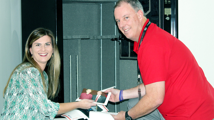 Nikki Perry, Lilburn’s city hall public relations manager, and Postmaster David Hinesley add items to the time capsule.