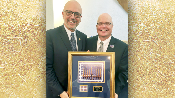 U.S. Rep. Ted Deutch of Florida and Chief Operating Officer David Williams display framed Hanukkah stamp artwork.