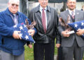 At the Buffalo, NY, P&DC, Driver Instructor Marty Abramson, left, an Air Force retiree, and Mail Processing Clerk Eric Sporysz, right, a Coast Guard veteran, receive an award named after Marine Corps retiree Frank Cius, who was a Vietnam prisoner of war from 1967-73. Cius worked at the Buffalo P&DC for 22 years before his retirement in 2006.