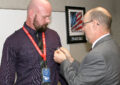 Southern Area VP Shaun Mossman, right, an Army veteran, places a lapel pin on Operations Analyst Chris Farlow at a ceremony in Dallas.