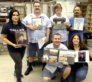 Veterans at the Rohnert Park, CA, Post Office display phots of themselves during their military careers. Standing, from left, are Postmaster Celestina Buckley; Tom Jones and Dolores Wilson-Condon, letter carriers; and Claro Efe, distribution clerk. Kneeling are Lario Cortex and Robin Walker, letter carriers.