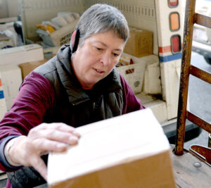 Cambridge, MD, Rural Carrier Ashlie Thorsteinsson loads a delivery vehicle with packages.