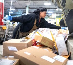 Jaadell Clayton, a clerk at the Omaha, NE, Processing and Distribution Center, helps sort parcels. Image: Omaha World-Herald