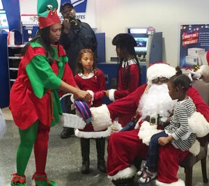 Chicago Postmaster Tangela Bush and Santa Claus — a.k.a. Mechanic Eddie Spearman — hand out gifts and welcome children at Chicago District’s Operation Santa kickoff.