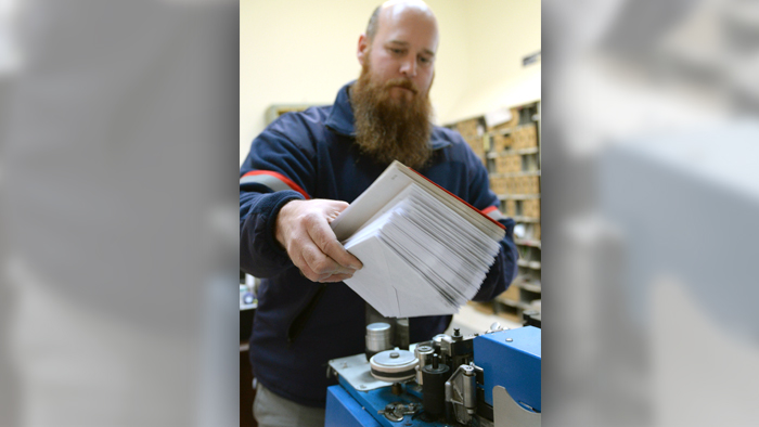 Chadwick Ruckart, a postal support employee in Bethlehem, MD, affixes the Post Office’s popular postmark to mail.