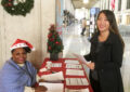 Iris Gaddis Hazel, a retired business mail clerk who volunteers for the USPS Operation Santa program, greets a customer at the James A. Farley Post Office in New York City.