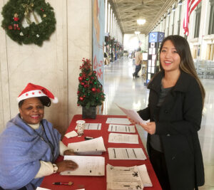 Iris Gaddis Hazel, a retired business mail clerk who volunteers for the USPS Operation Santa program, greets a customer at the James A. Farley Post Office in New York City.