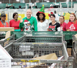 The holiday team at the Ybor City, FL, Processing and Distribution Center includes, from left, Postal Support Employee clerks Monica Ware and Samatha Hill, Distribution Operations Acting Manager Jeremy Wray, Distribution Operations Manager Kim Crompton, and mail processing clerks Kim Schaefer, Yvonne Delutri and Angela Sayre.