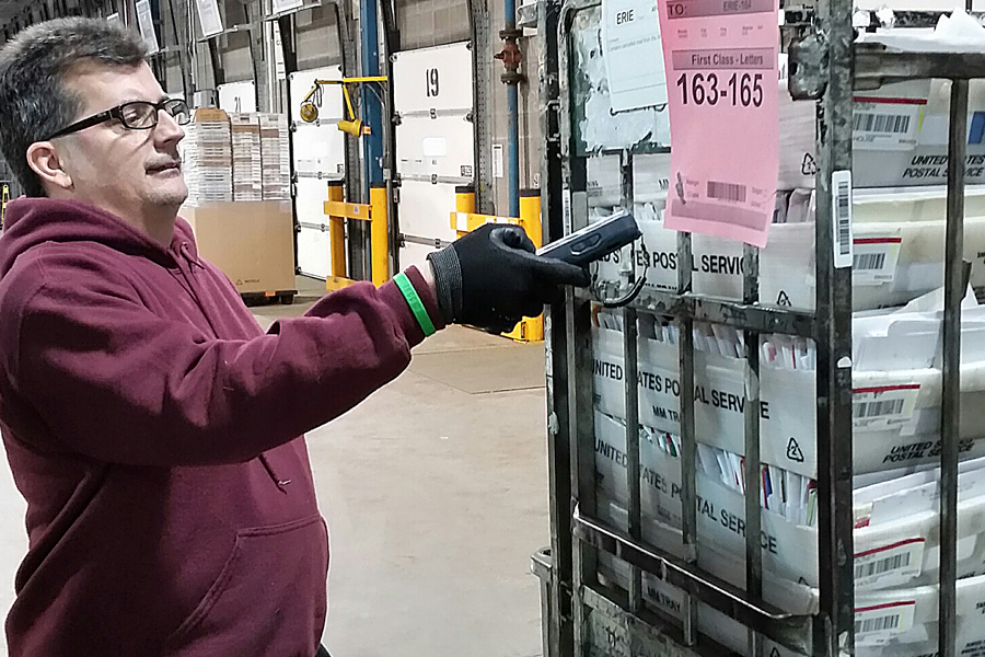 Mail Handler Phil Cassano uses a surface visibility device to scan a container label at the Erie, PA, Processing and Distribution Center.